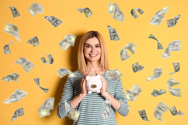 Mujer feliz con alcancía y dinero volando sobre fondo de color —  Fotos de Stock