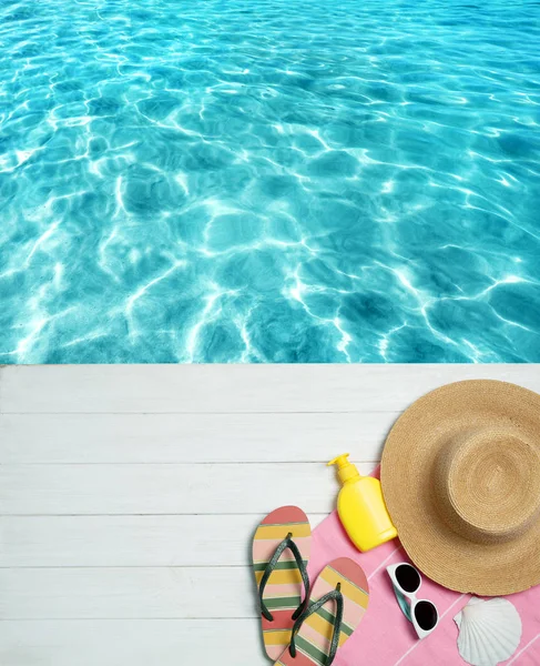 Flache Liegekomposition mit Strandzubehör auf Holzsteg am Wasser, Platz für Text — Stockfoto