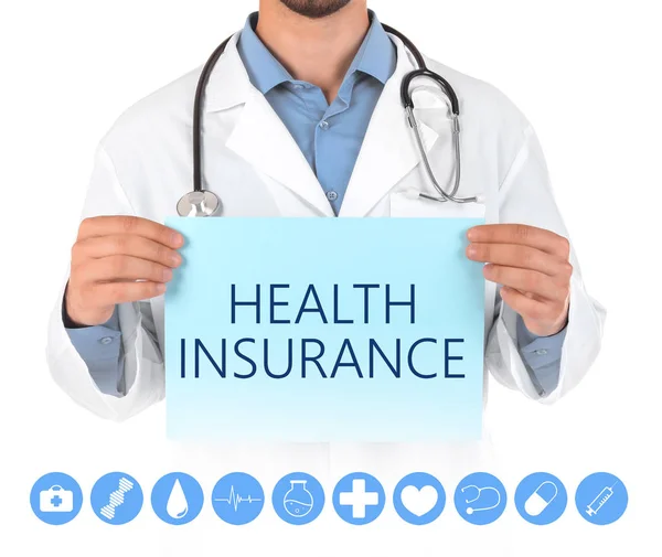Lékař, který drží papír s textem zdravotní pojištění na bílém pozadí, zaostřená — Stock fotografie