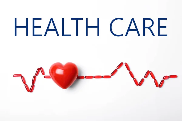 红心模型和药片上的白色背景,顶视图。健康保险 — 图库照片