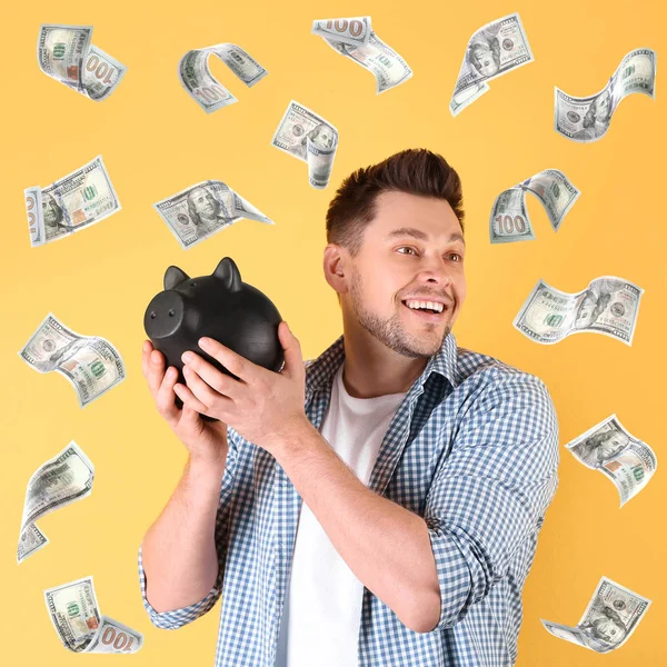 Happy man with piggy bank and flying money on color background — Stock Photo, Image