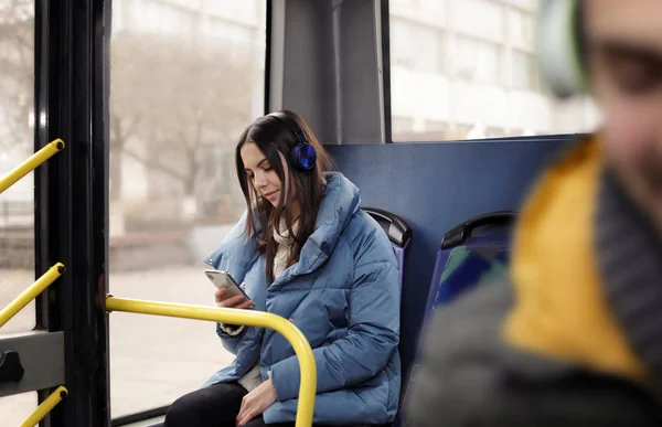 Mujer joven escuchando música con auriculares en el transporte público — Foto de Stock