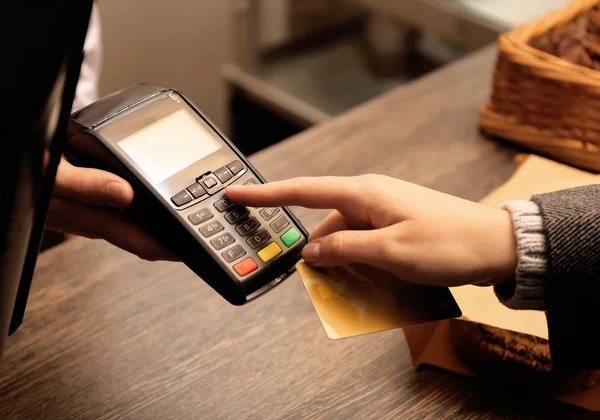 Woman with credit card using payment terminal at shop, closeup — 스톡 사진