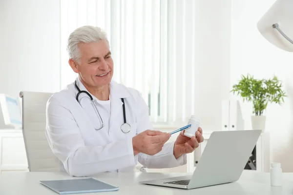 Lekarz konsultingu pacjenta za pomocą czatu wideo na laptopie w klinice — Zdjęcie stockowe