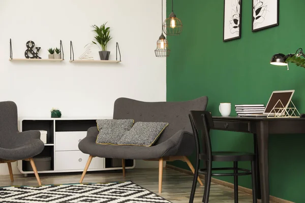 Sala de estar moderna interior com local de trabalho perto de parede verde — Fotografia de Stock