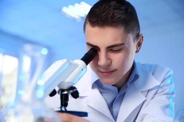 Cientista masculino usando microscópio moderno em laboratório de química — Fotografia de Stock