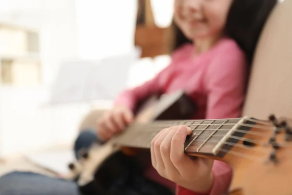 Dziewczynka gra na gitarze w domu, zbliżenie. Nauka nut — Zdjęcie stockowe