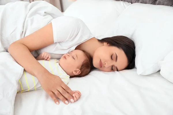 Mutter und ihr süßes Baby schlafen im Bett — Stockfoto