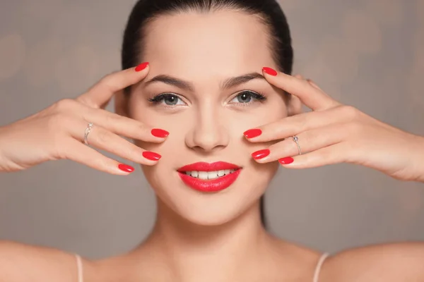 Mooie jonge vrouw met heldere manicure op wazige achtergrond, close-up. Nail Polish trends — Stockfoto