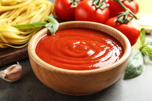 Чашка вкусного томатного соуса подается на стол, крупным планом — стоковое фото