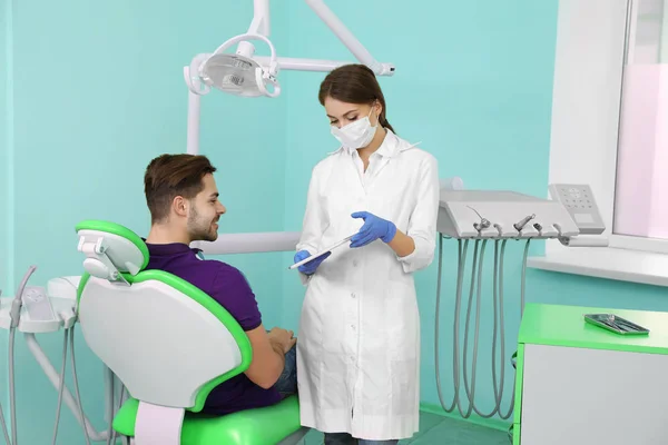 Dentista profissional e paciente na clínica moderna — Fotografia de Stock