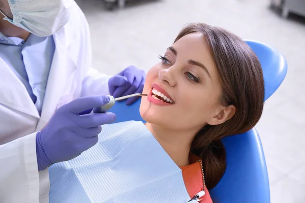 Dentiste professionnel travaillant avec le patient dans une clinique moderne — Photo