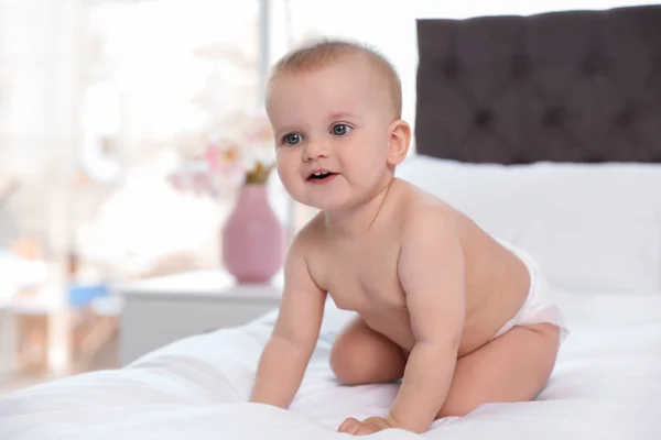 Cute baby in diaper on bed at home — Stock Photo, Image