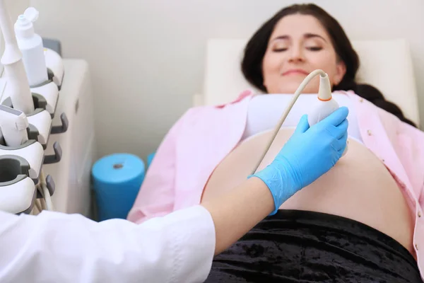 Young pregnant woman undergoing ultrasound scan in clinic — Stock Photo, Image