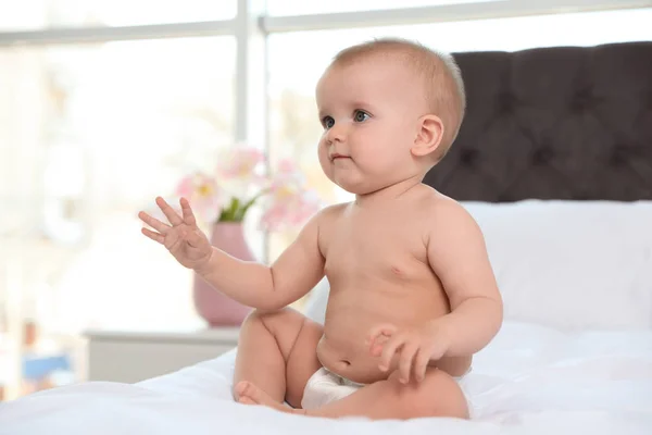 Söt bebis i blöja på sängen hemma — Stockfoto