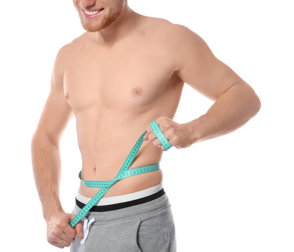Jonge man met meetlint toont zijn slanke lichaam op witte achtergrond, close-up — Stockfoto