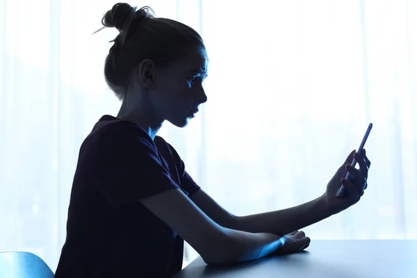 Menina adolescente chocada com smartphone na mesa dentro de casa. Perigo da internet — Fotografia de Stock