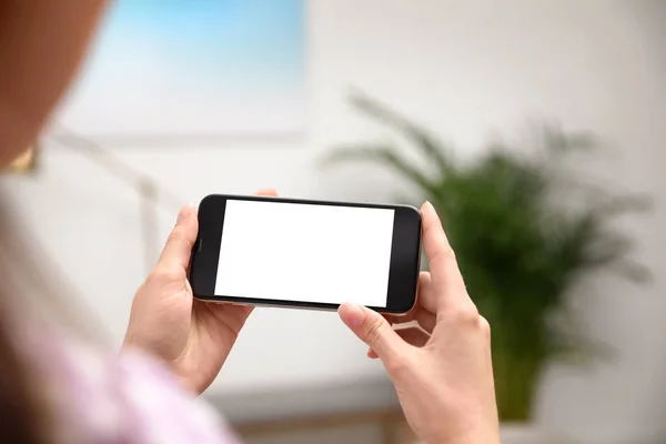 Frau hält Smartphone mit leerem Bildschirm drinnen, Nahaufnahme der Hände. Raum für Text — Stockfoto