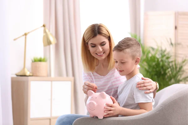 Family with piggy bank and money at home. Space for text