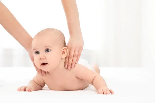 Mutter und ihr süßes Kind auf dem Bett drinnen, Platz für Text. Babymassage und Übungen — Stockfoto