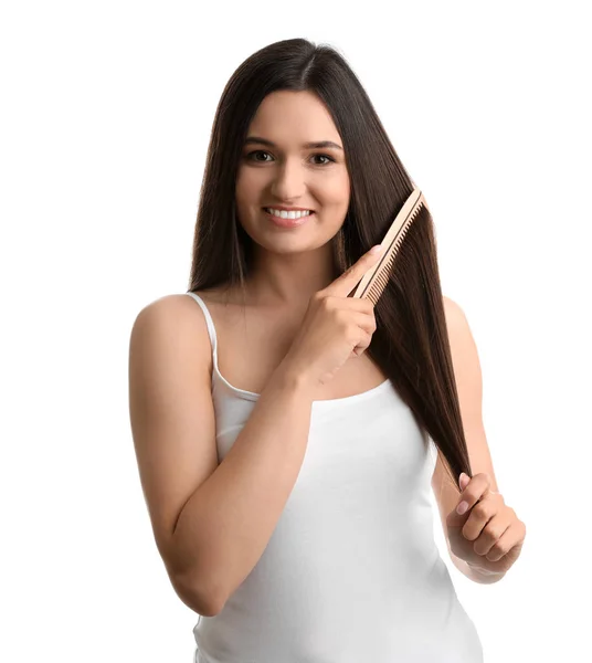 Mulher bonita com pente de cabelo no fundo branco — Fotografia de Stock