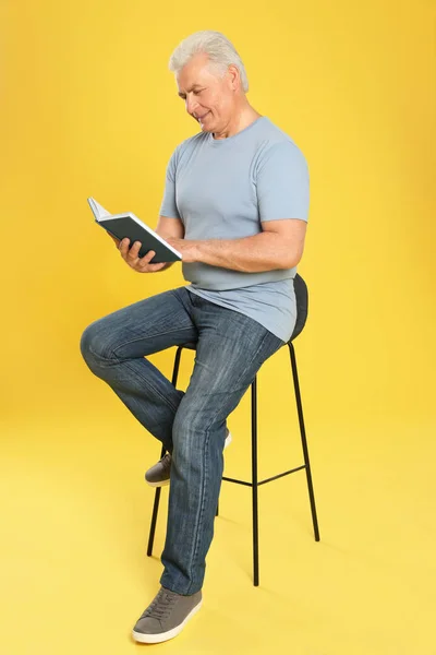 色の背景に本を読んでシニア男性 — ストック写真