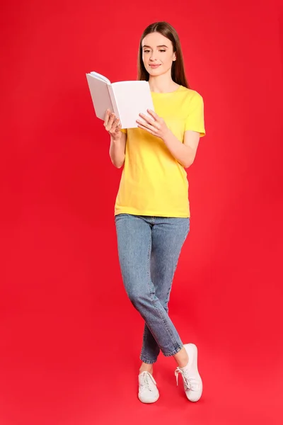 Fiatal nő olvasás könyv színes háttér — Stock Fotó