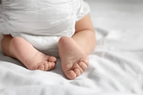 Niedliches kleines Baby, das auf weißem Bettlaken krabbelt, Nahaufnahme. Raum für Text — Stockfoto
