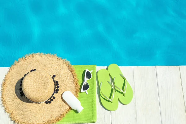 Flache Liegekomposition mit Strandzubehör auf Holzdeck in der Nähe des Swimmingpools. Raum für Text — Stockfoto