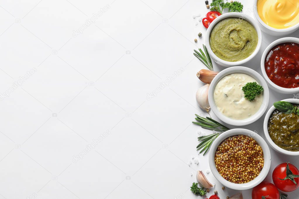 Composition with different sauces and ingredients on white background, flat lay. Space for text