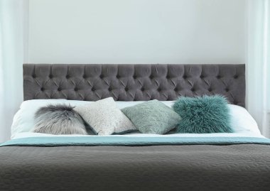 Farklı yastıklar ve hafif odada ekose ile rahat yatak. İç dekor için fikir