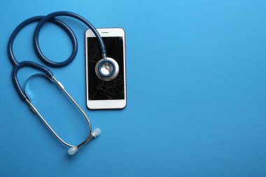 Renkli arka planda metin için kırık ekran, stetoskop ve alan ile modern smartphone, düz yatıyordu. Cihaz onarım hizmeti