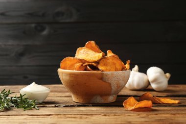 Masa üzerinde kase, biberiye ve sos lezzetli tatlı patates cips