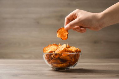 Kadın alma tatlı patates Chip gelen Bowl üzerinde tablo, kapatmak