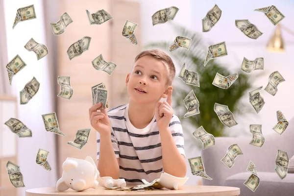 Little boy with broken piggy bank and money at home — Stock Photo, Image