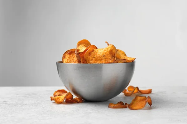 Tazón de fuente y patatas fritas en la mesa sobre fondo claro —  Fotos de Stock