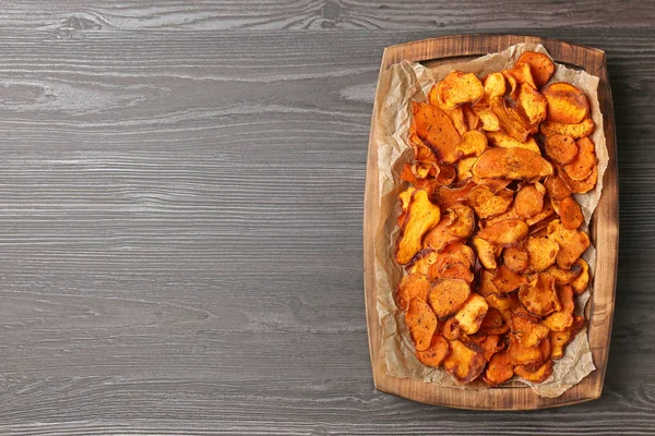 Tablett mit Süßkartoffelchips auf Holztisch, Draufsicht. Raum für Text — Stockfoto