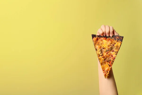 Mulher segurando fatia de pizza preta no fundo de cor, close-up. Espaço para texto — Fotografia de Stock