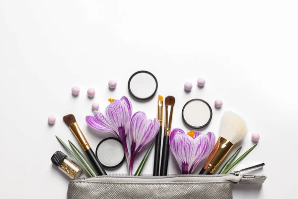 Make-up producten, bloemen en cosmetische tas op witte achtergrond, bovenaanzicht — Stockfoto