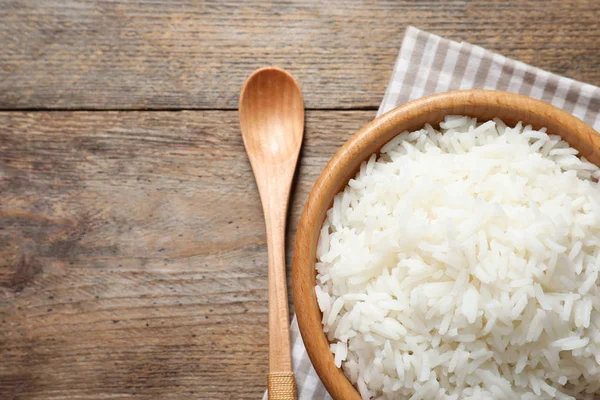 Tigela de arroz delicioso na mesa de madeira, vista superior com espaço para texto — Fotografia de Stock