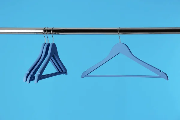 Металлическая стойка с вешалками для одежды на цветном фоне — стоковое фото