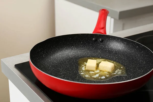 Сковородка с плавильным маслом на электрической плите — стоковое фото