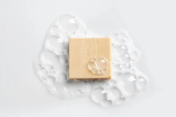 Soap bar and foam on white background, top view. Mockup for design — Stock Photo, Image