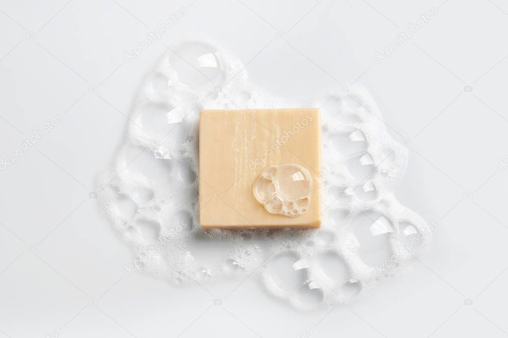 Soap bar and foam on white background, top view. Mockup for design