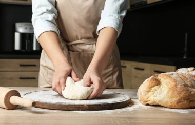 Bayan fırıncı masada ekmek hamur hazırlamak, kapatmak