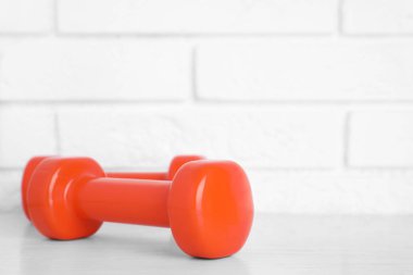 Tuğla duvar, metin alanı karşı masada şık dambıl. Ev fitness