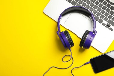 Modern kulaklıklar, telefon ve dizüstü renkli arka plan, düz yatıyordu. Metin alanı