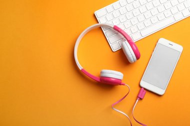 Modern kulaklıklar, telefon ve klavye renkli arka plan, düz yatıyordu. Metin alanı