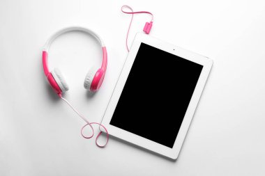 Şık kulaklıklar ve beyaz arka planda modern tablet, üst görünüm. Metin alanı