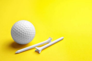 Golf topu ve Tees renk arka planda, metin için alan. Spor ekipmanları